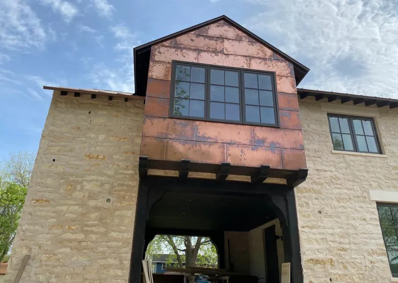 Copper metal panel facade on a stone building for Skylight Installation in Cloquet